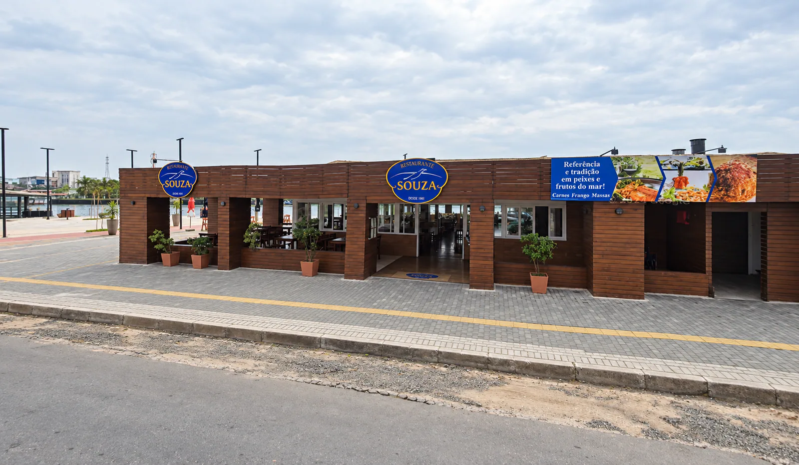 Fachada do Restaurante Souza com revestimento de madeira e logos azuis