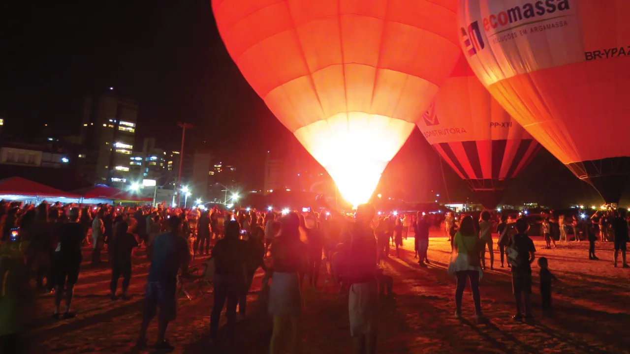 Balões iluminados à noite diante do público em Torres