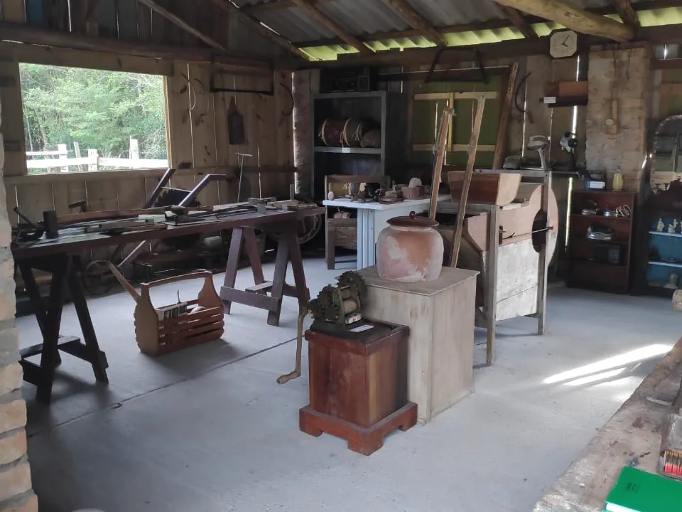 Interior do Museu Rural do Sítio Vô Inácio, com ferramentas e bancada antiga