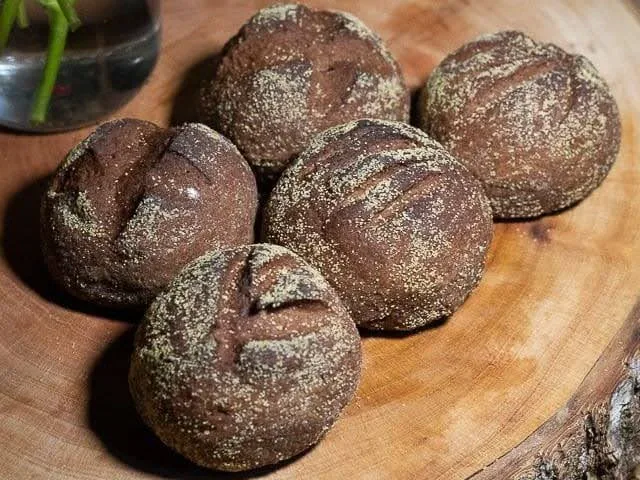 Pães rústicos redondos da Terra Padaria Artesanal sobre uma tábua de madeira